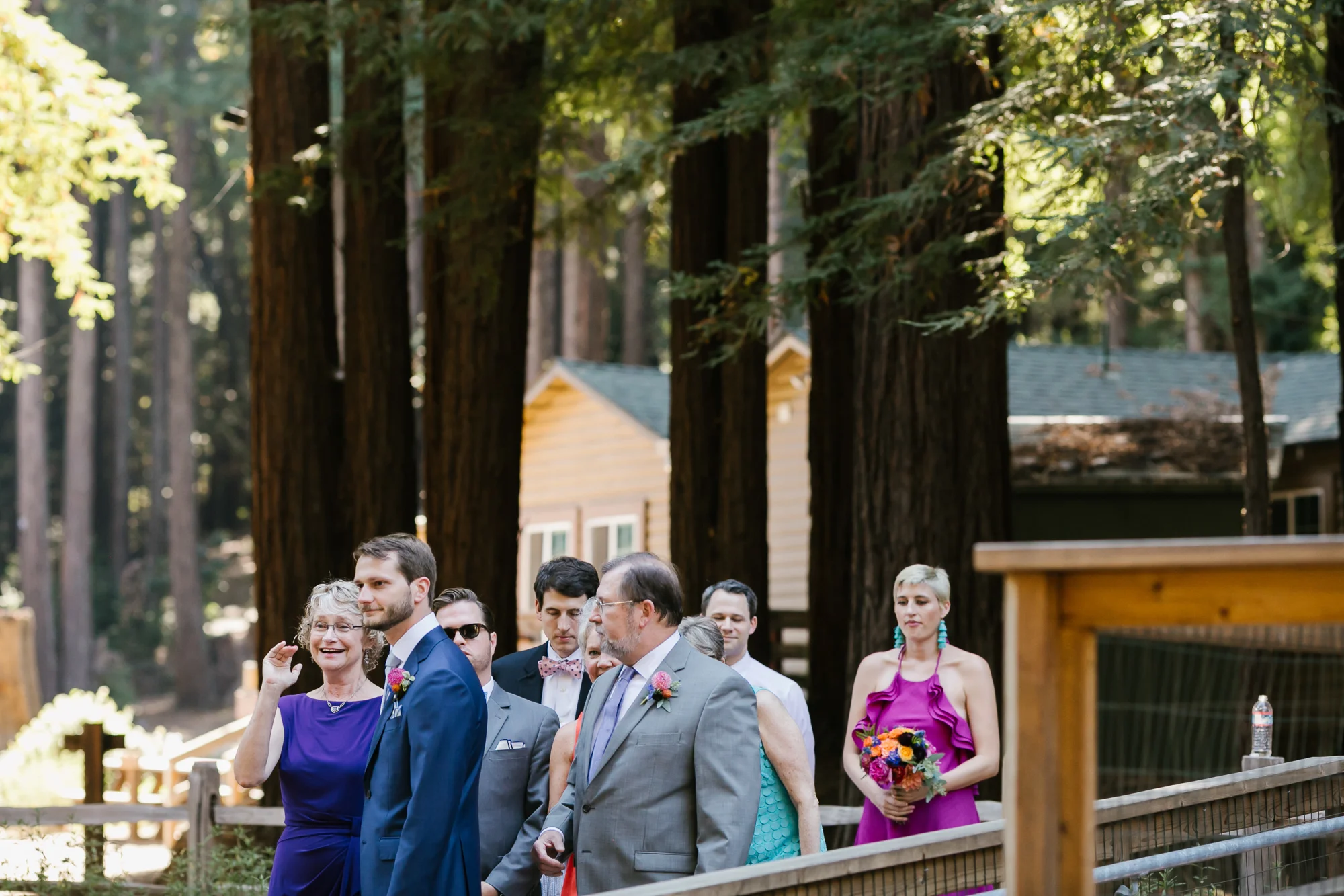 Groom lines up before ceremony with his parents at camp wedding