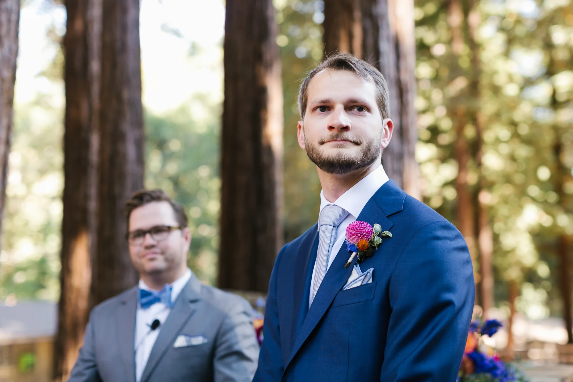 Groom in blue suit gets emotional watching his bride walk down the aisle