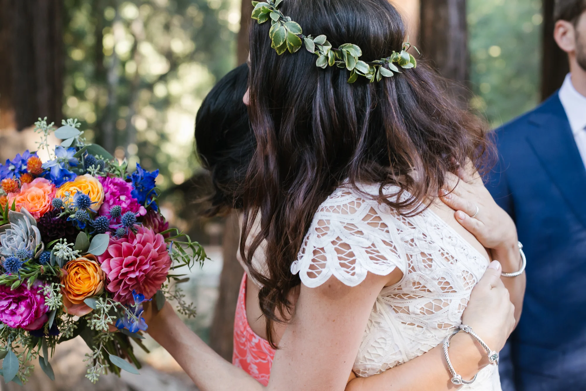 Bride with bright bouquet hugs her family