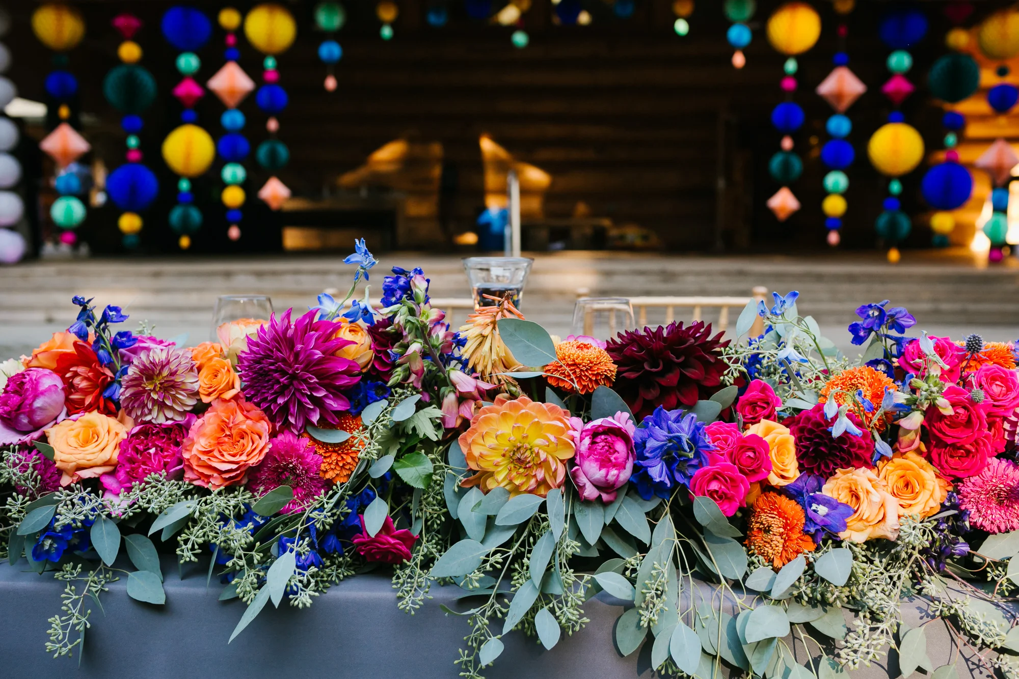Sweetheart table is covered in large colorful flowers