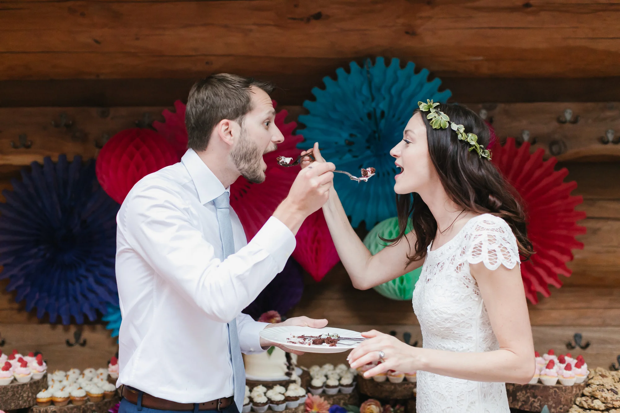 Wedding couple exchange bites of their wedding cake