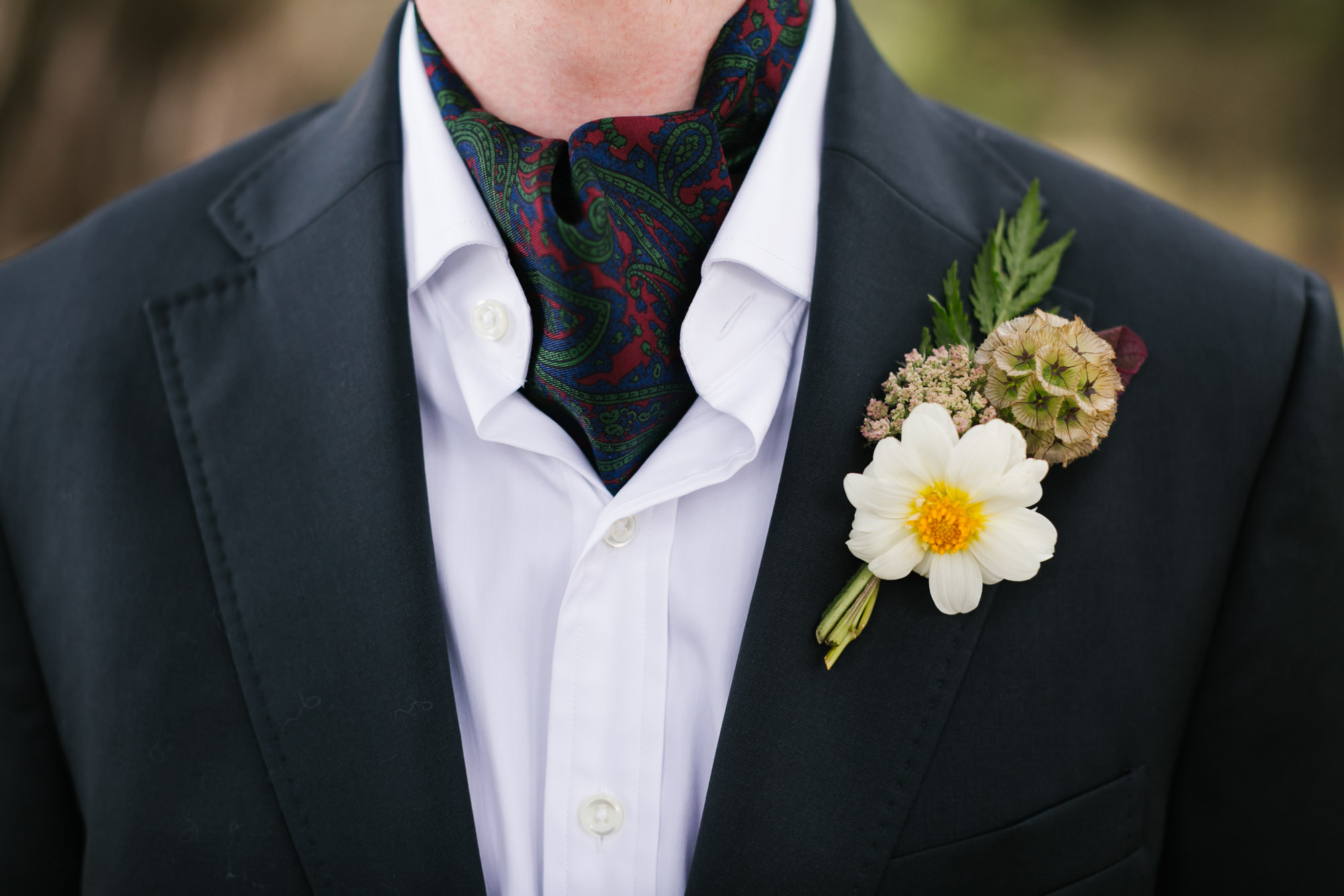 Groom's wedding suit with paisley ascot and boutonniere