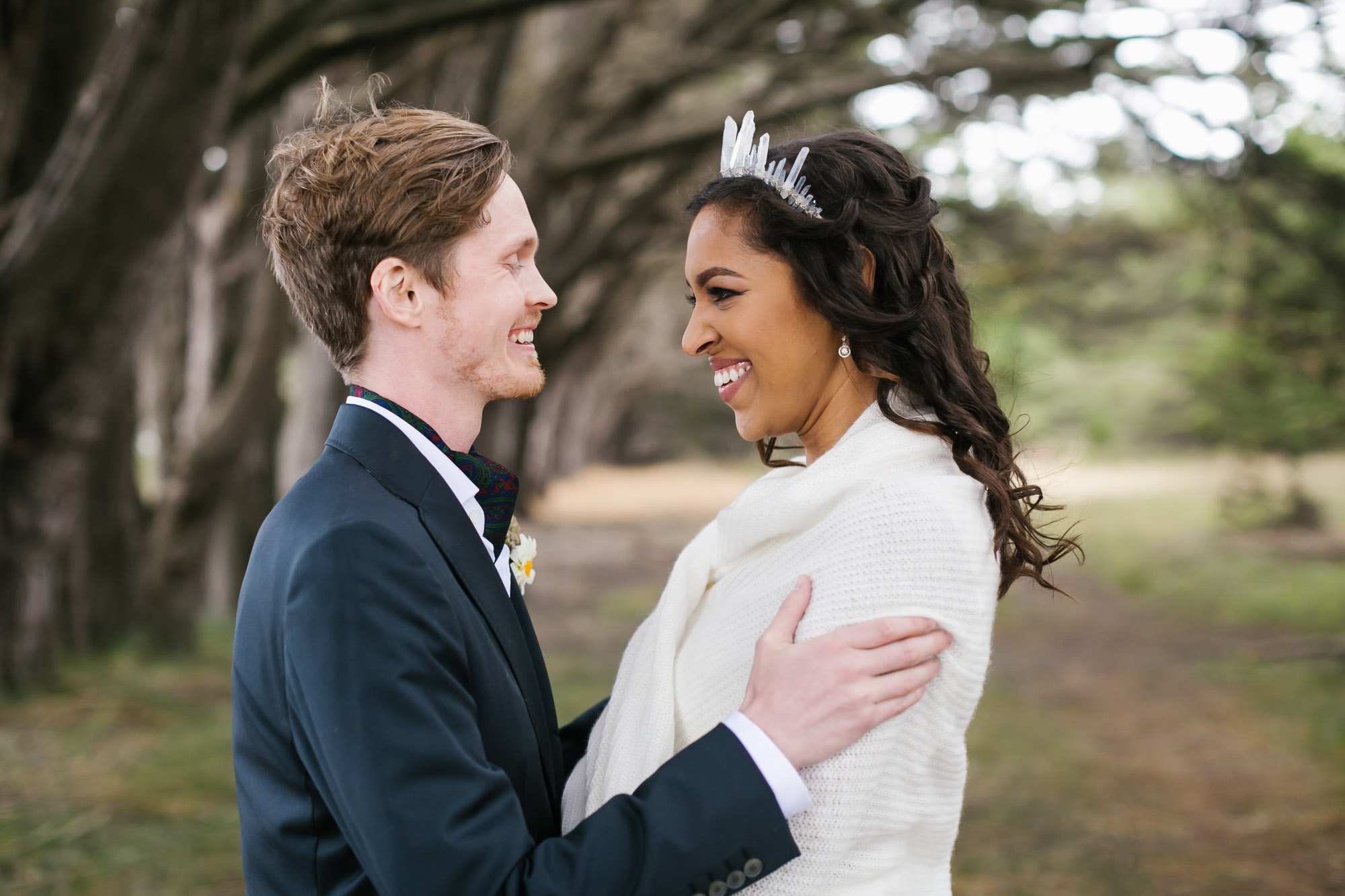 Bride wearing crystal crown and white fur stole kept warm by her husband