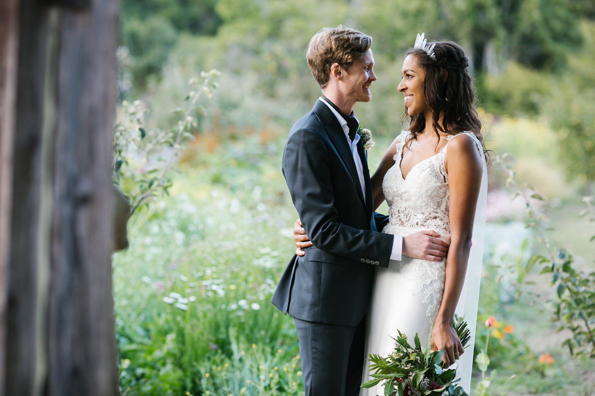 Wedding couple smile on coastal flower farm with greenhouse