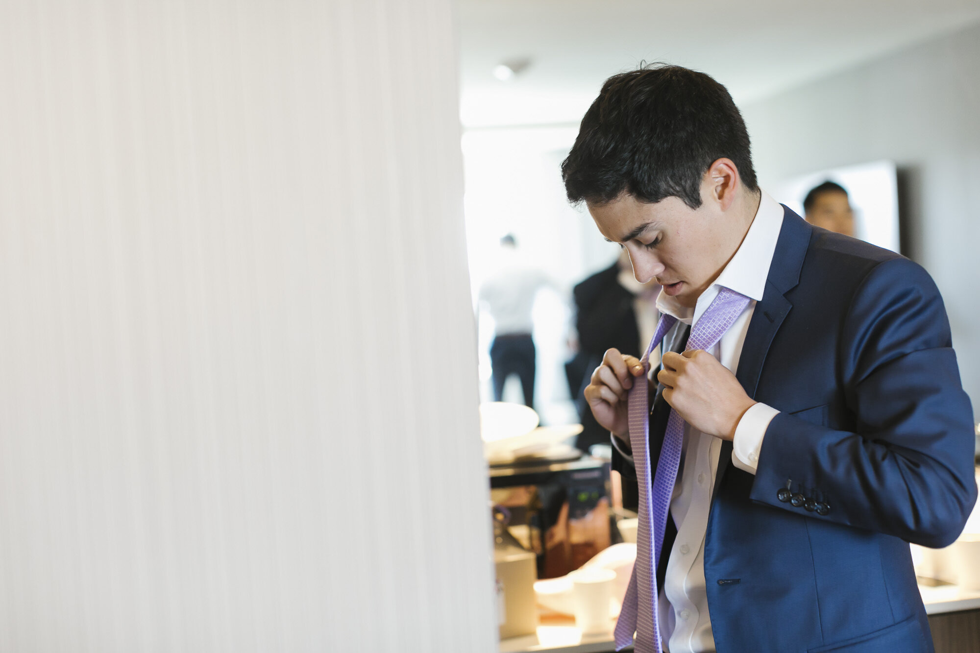 Groom in blue suit gets ready on his wedding day