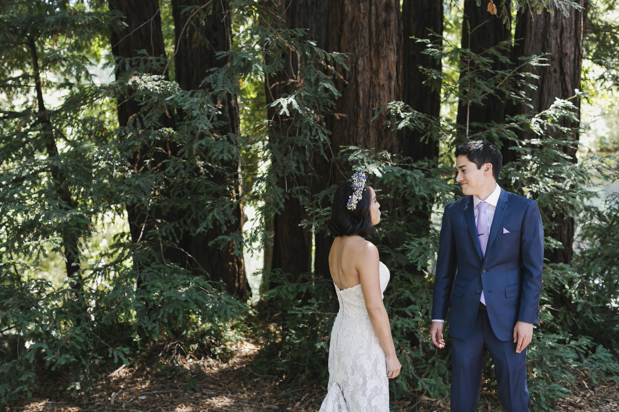 Groom sees his bride for their first look in a redwood forest