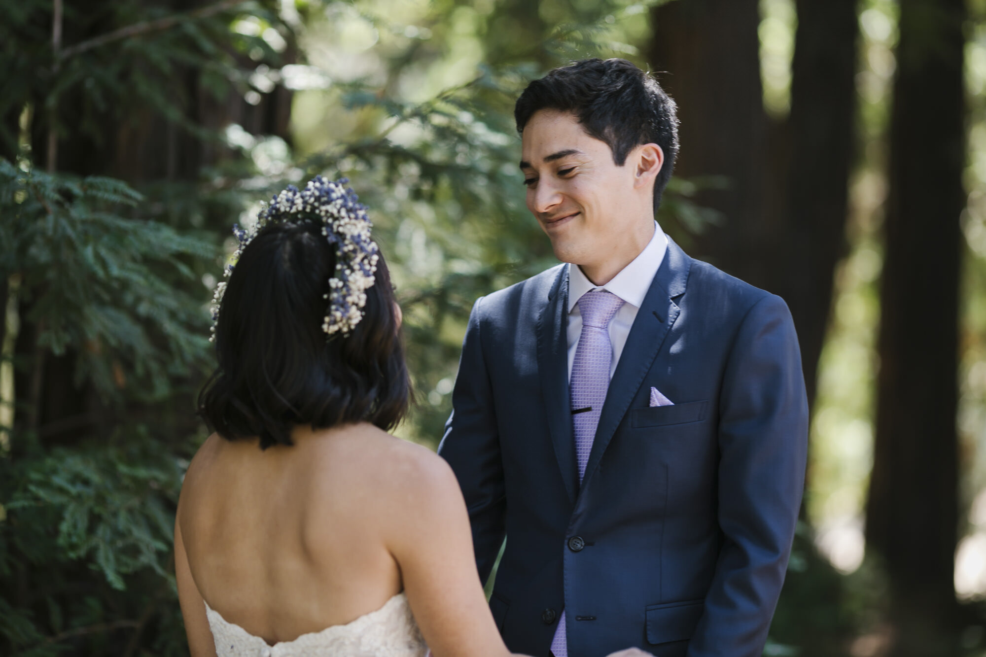 Groom smiles at his bride in a redwood forest
