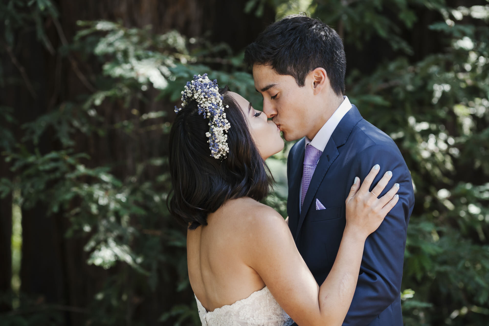 Bride and groom kiss under the redwood trees