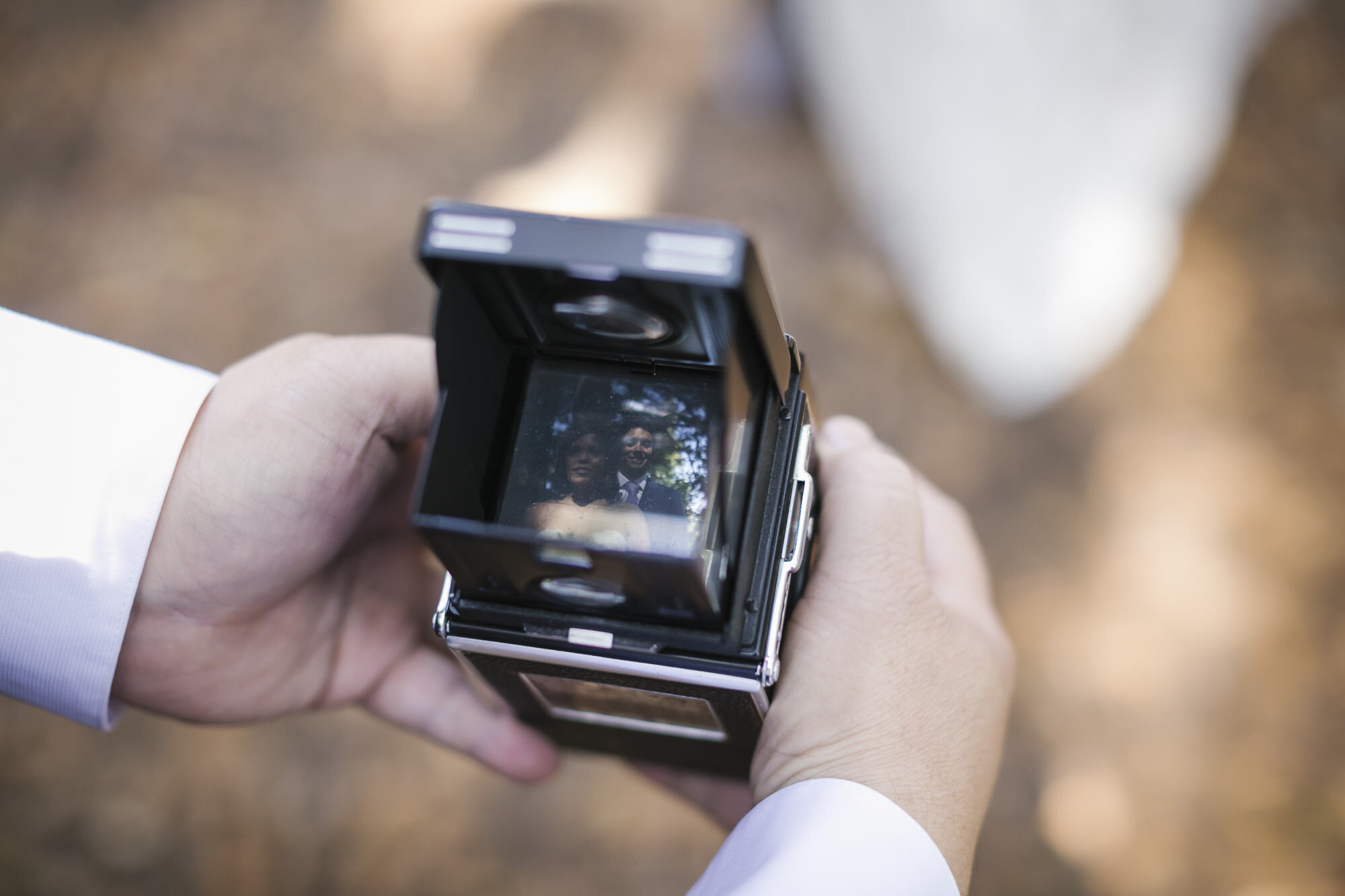 Guest takes portrait of wedding couple with Rolleiflex camera