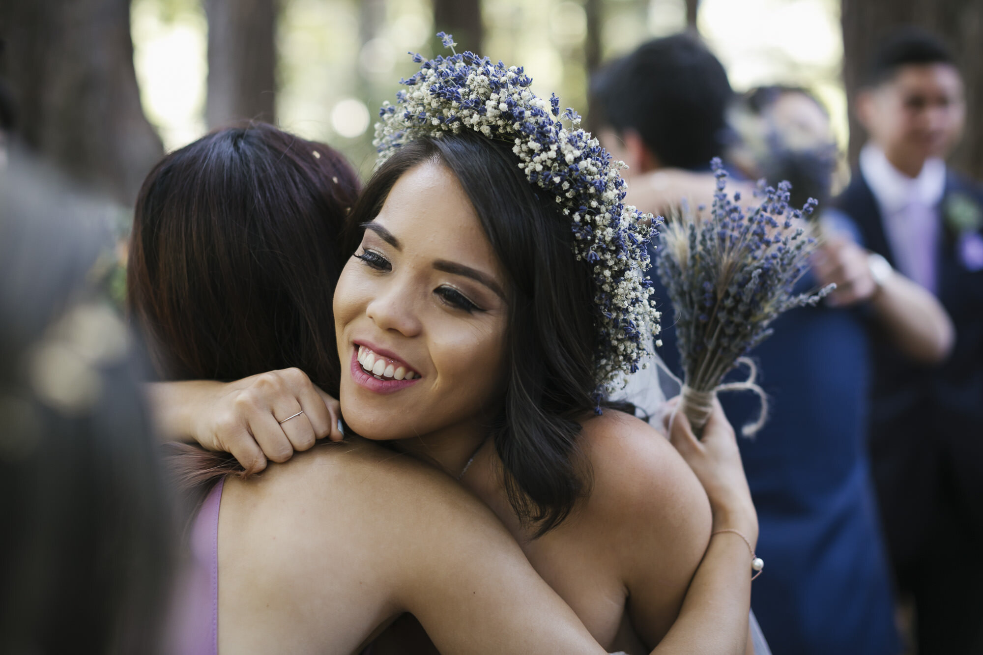 Wedding party hugs bride and groom after ceremony