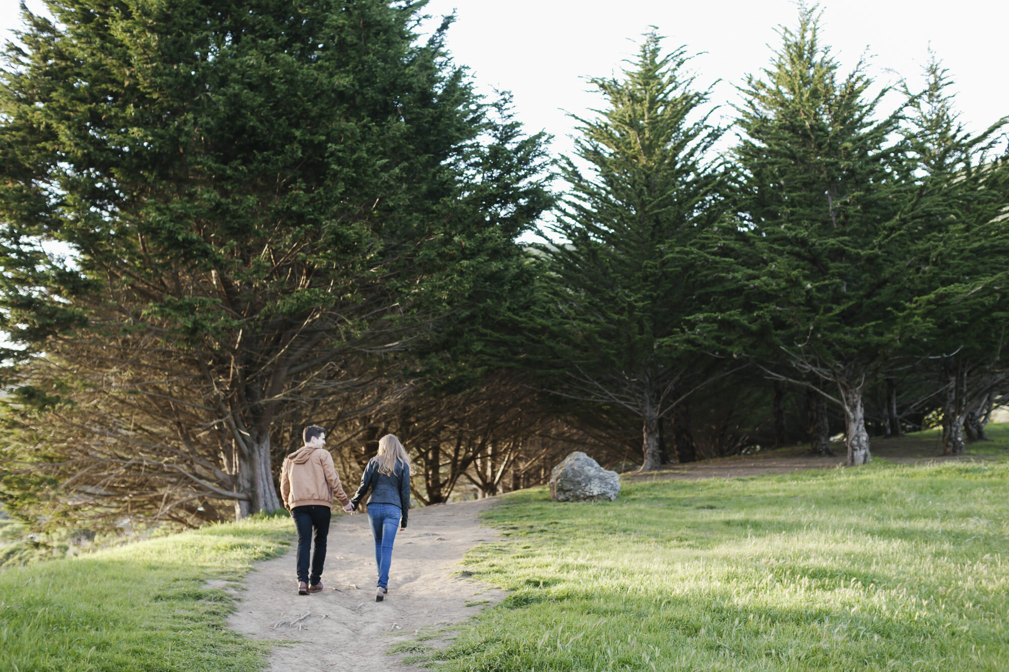 Engaged couple walk around Slide Ranch in Marin