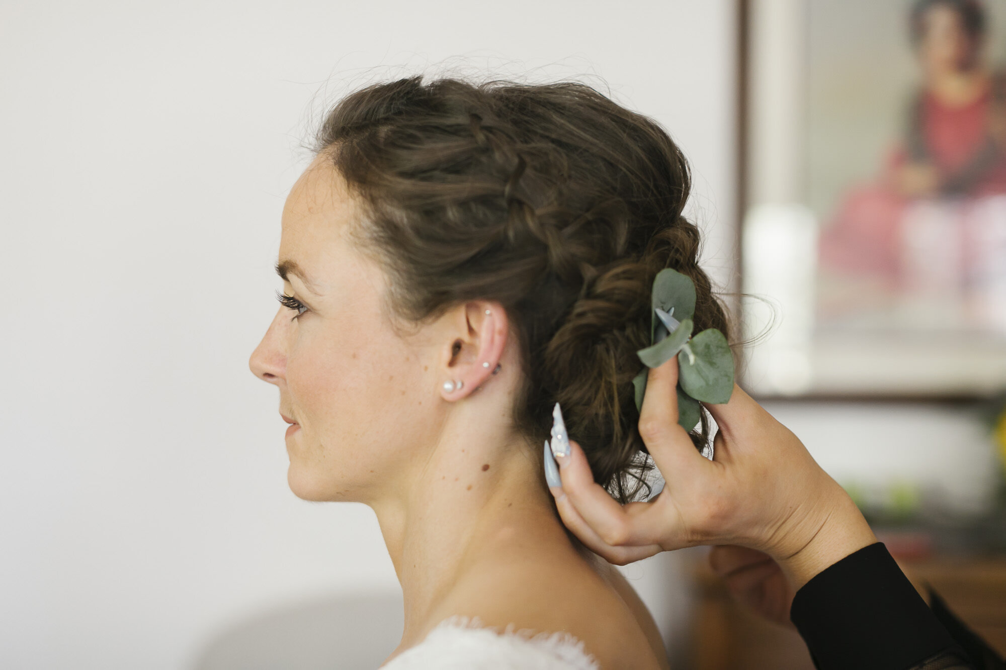 Bride puts greenery in her hair on her wedding day