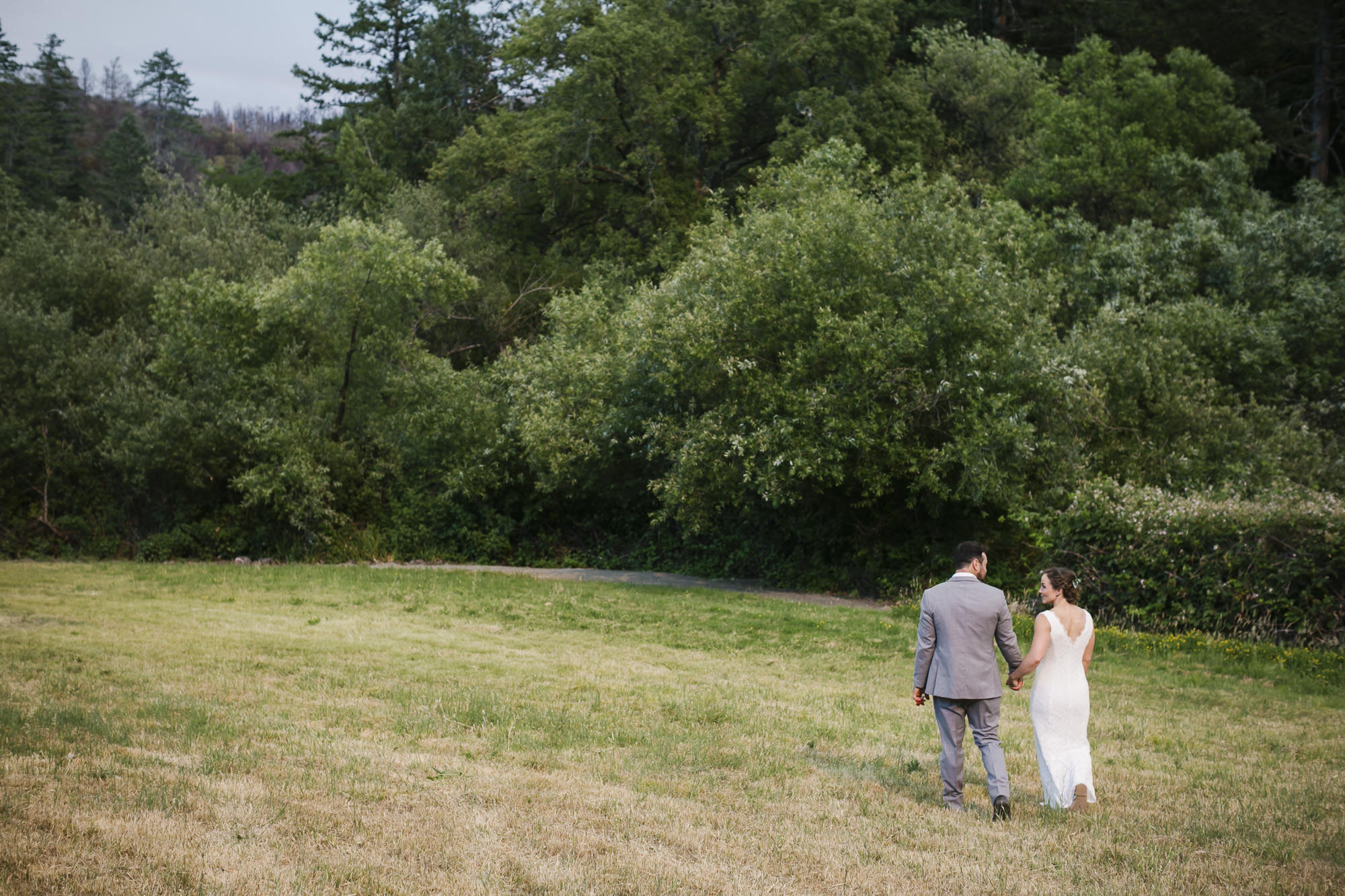 Wedding couple walk together after their backyard ceremony in Sonoma