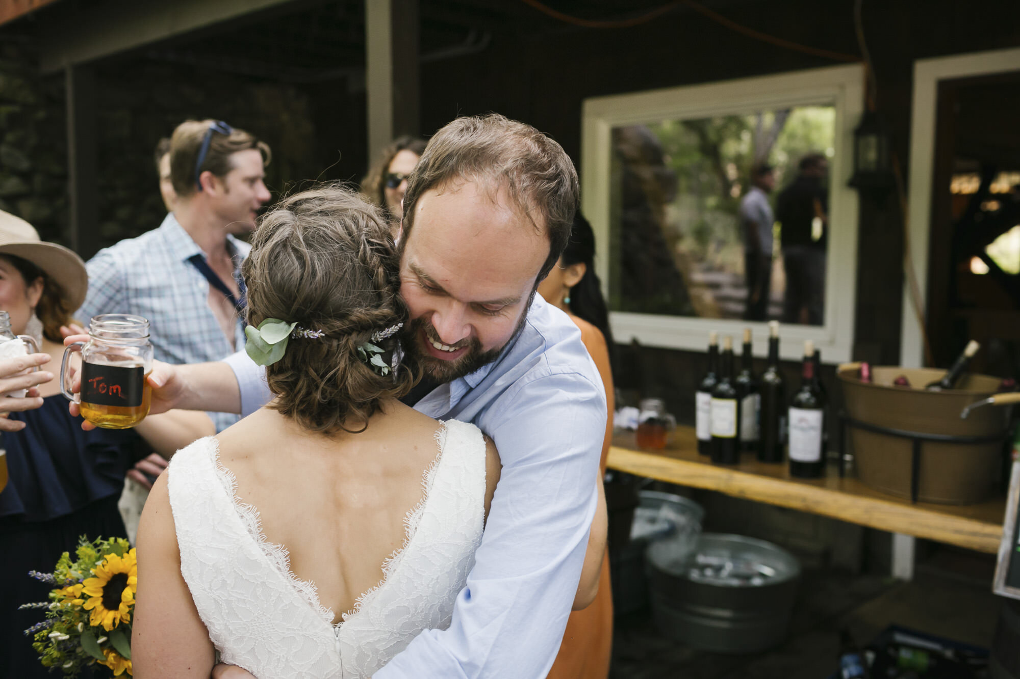Bridge hugs friend at backyard wedding reception in Sonoma California