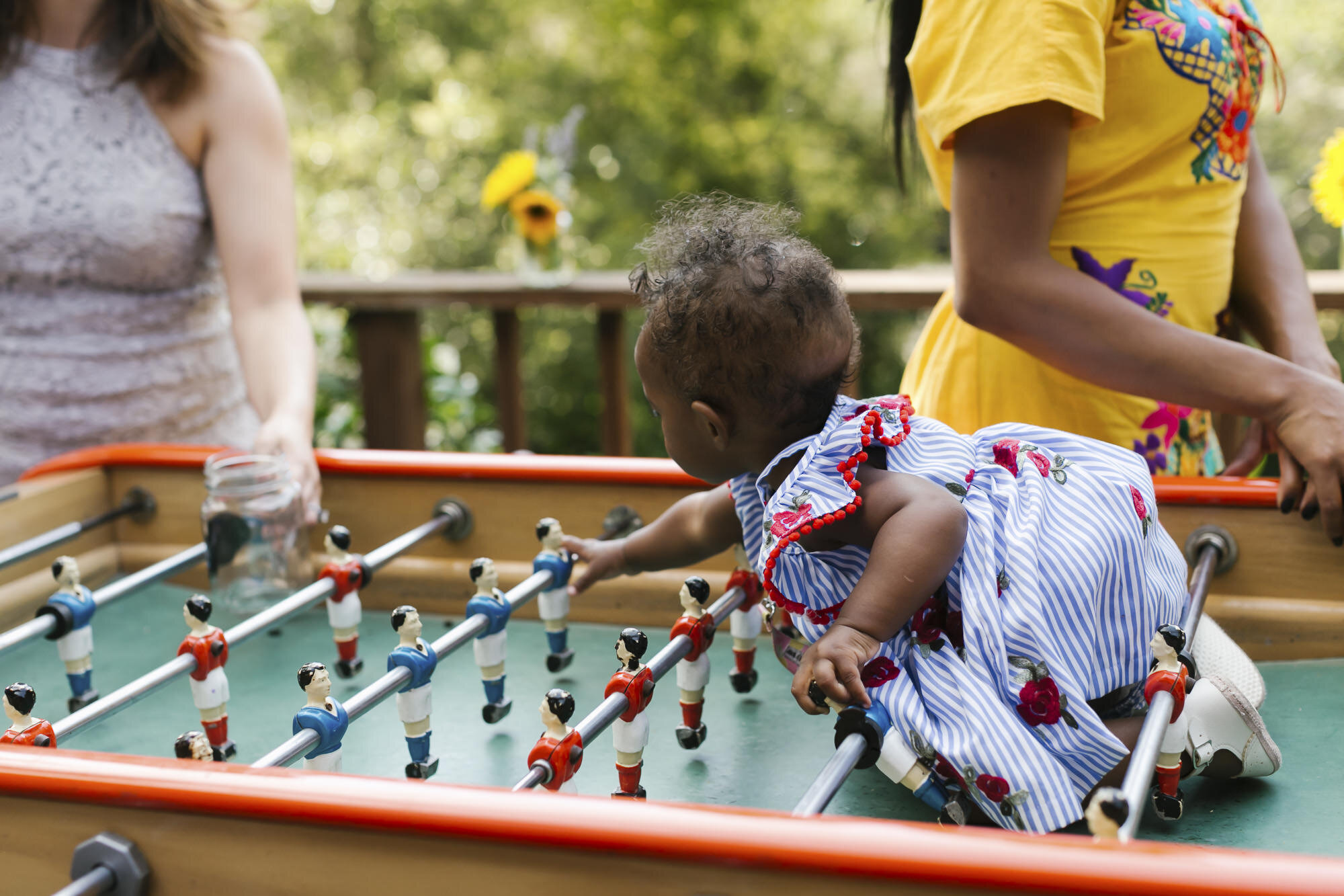 Cute baby on foosball table at backyard wedding reception in Sonoma California