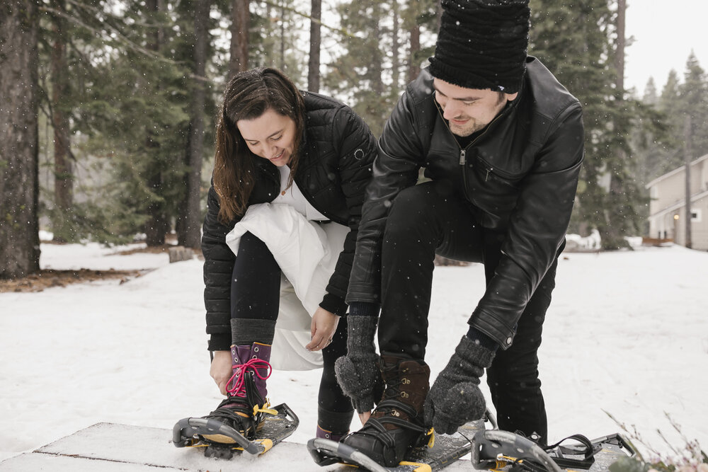 Wedding couple strap on their snowshoes for their winter elopement in Lake Tahoe