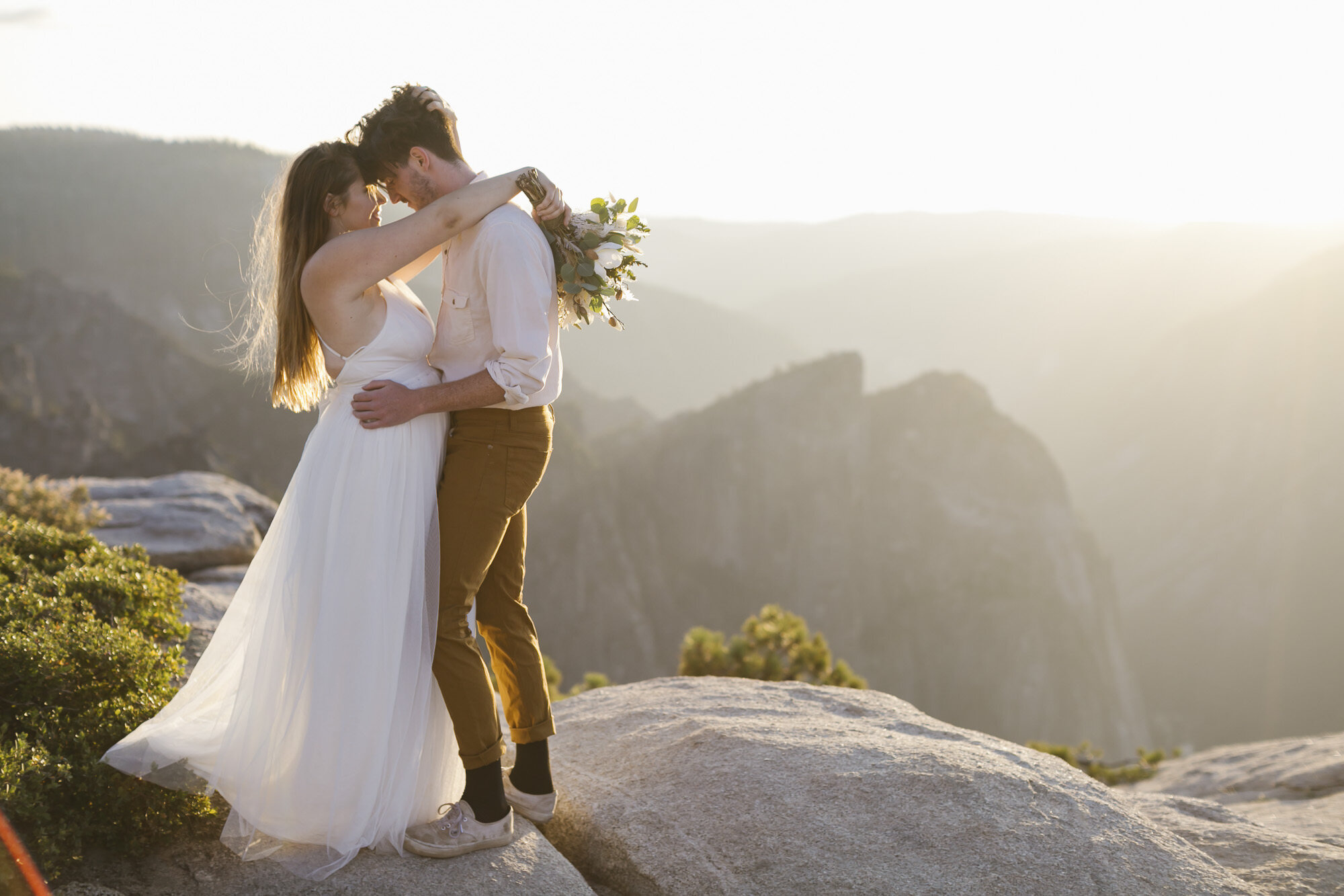 Bride and groom hug at Taft Point during their adventure elopement in Yosemite