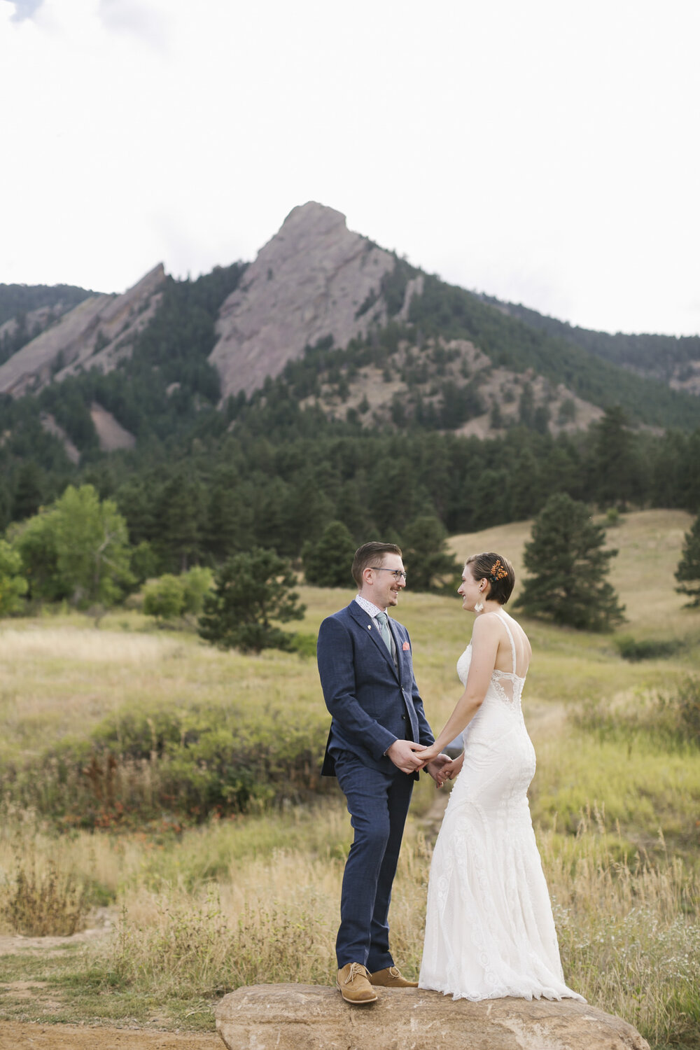 Elopement couple stand in front of the Flatirons near Boulder Colorado