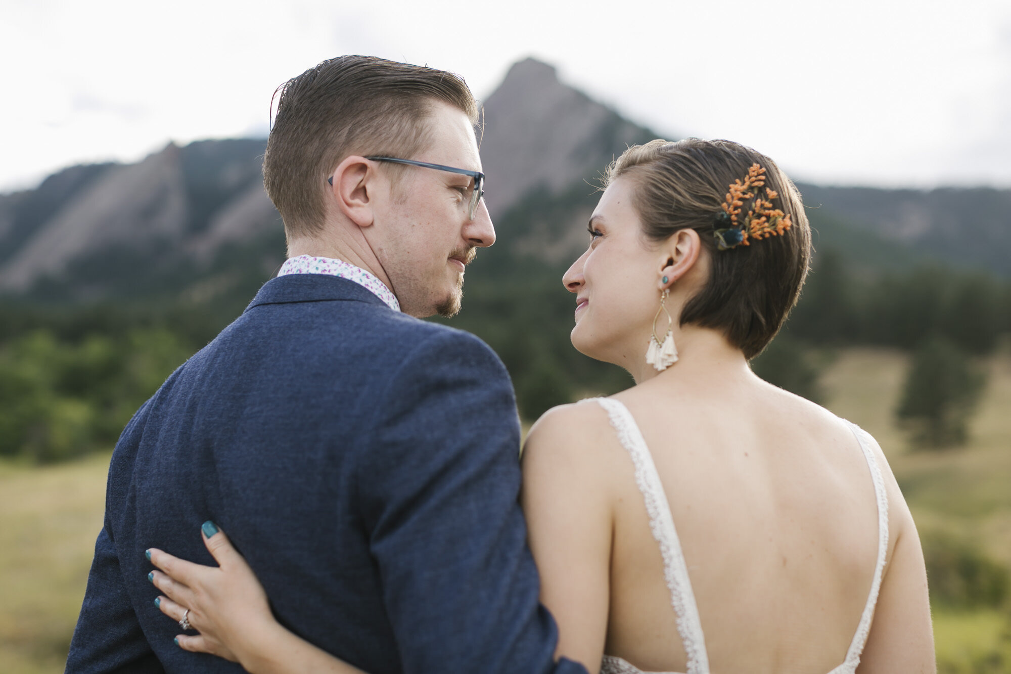 Wedding couple stand together with Flatirons in the background