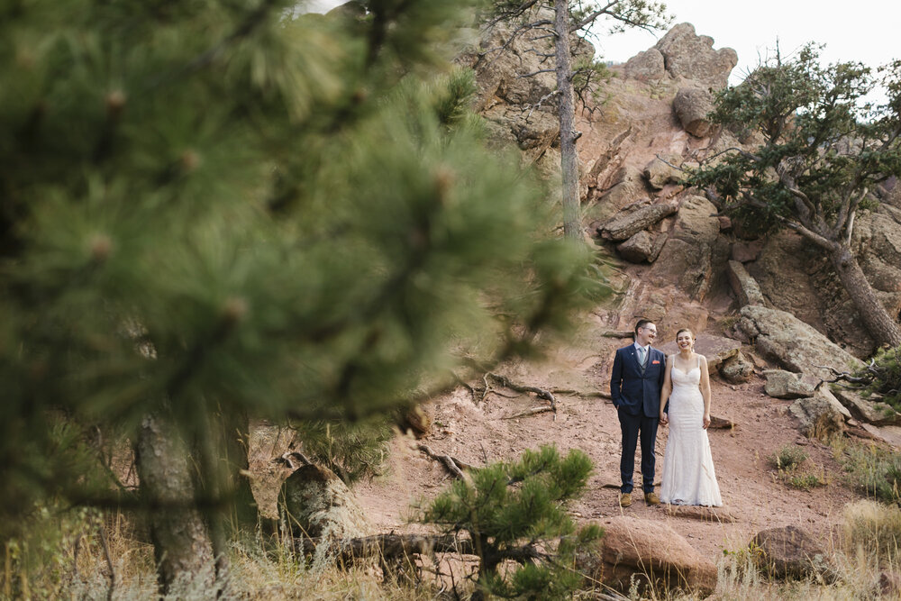 Wedding couple stand among the red rocks at Flagstaff mountain in Colorado