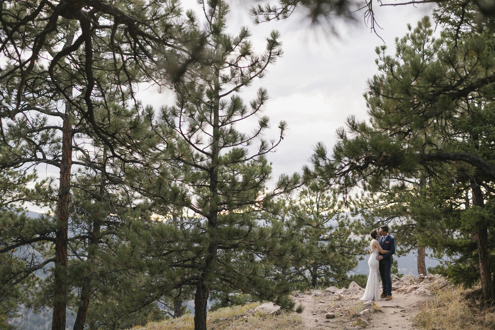 Wedding couple kiss in a pine forest near Boulder Colorado