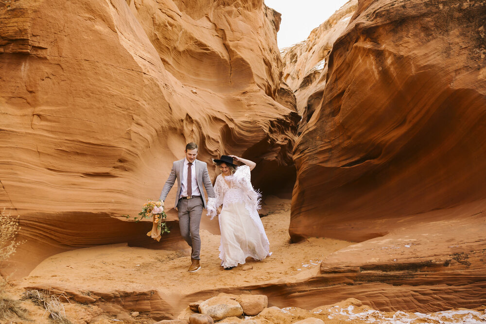 Elopement couple run through a slot canyon in Arizona