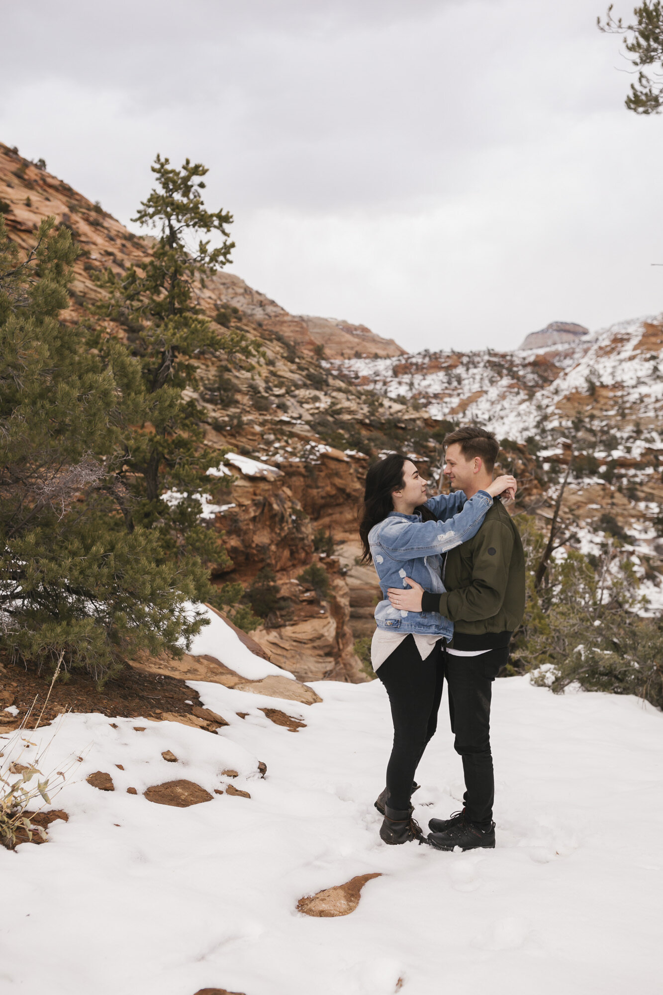 Couple hold each other close during their winter engagement session in Zion