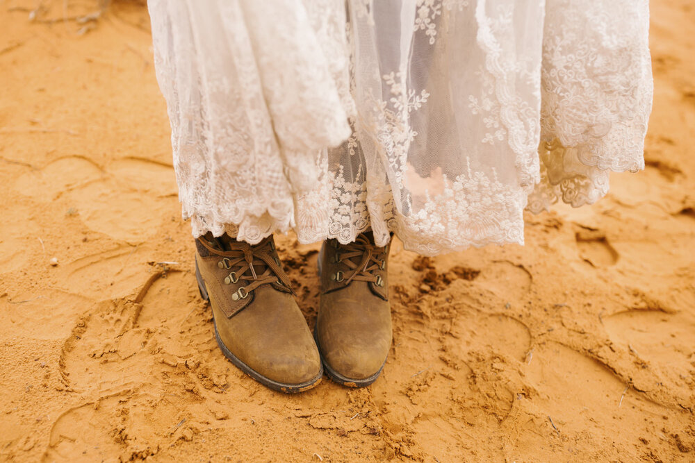 Eloping bride's boots among the orange dirt at Monument Valley