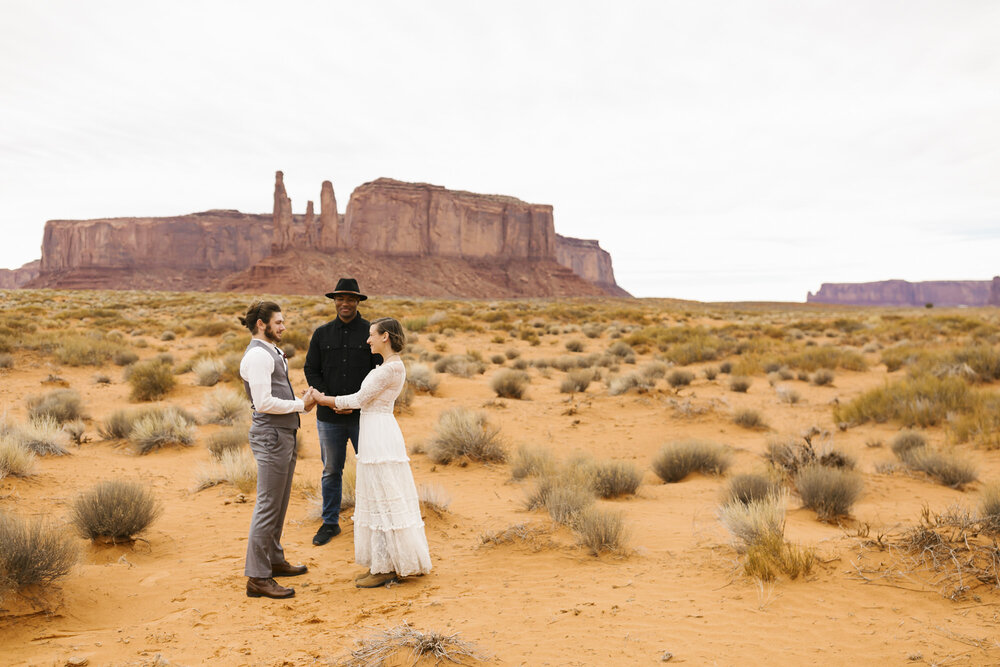 Bride and groom exchange vows in the desert at their Monument Valley wedding