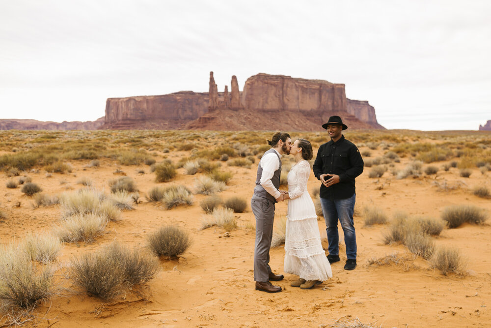 Couple kiss after exchanging vows in the Arizona desert at their Monument Valley wedding