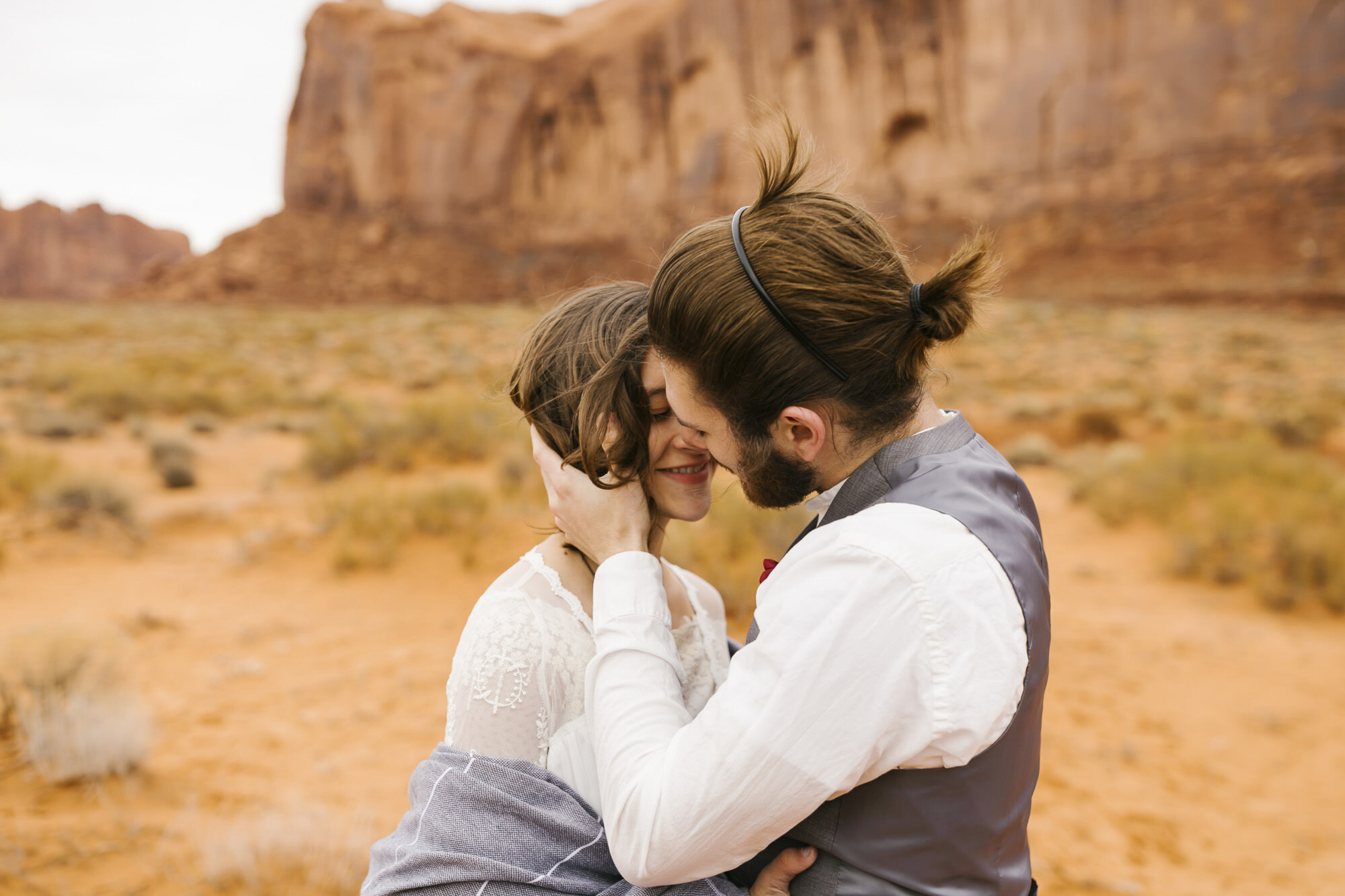 Adventurous wedding couple kiss in Monument Valley after their ceremony
