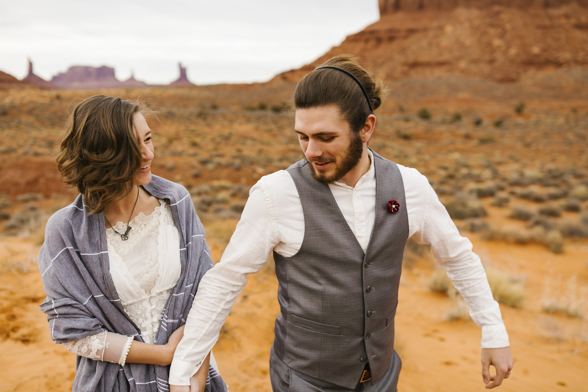 Couple walk together through Monument Valley on their wedding day