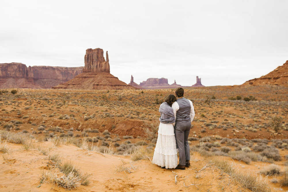 Just married couple enjoy the scenery and the Mittens in Monument Valley Arizona on their wedding day