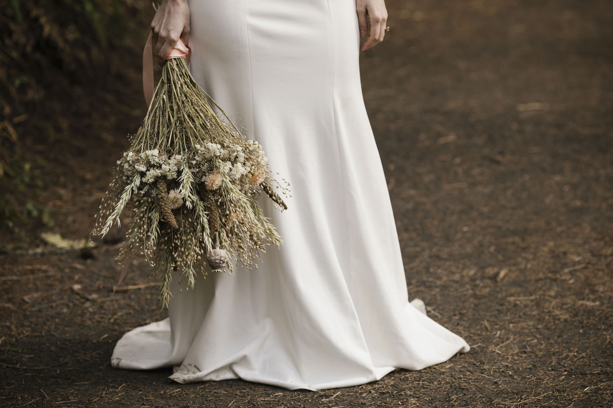 Wedding bouquet made of dried flowers with bottom of bride's dress