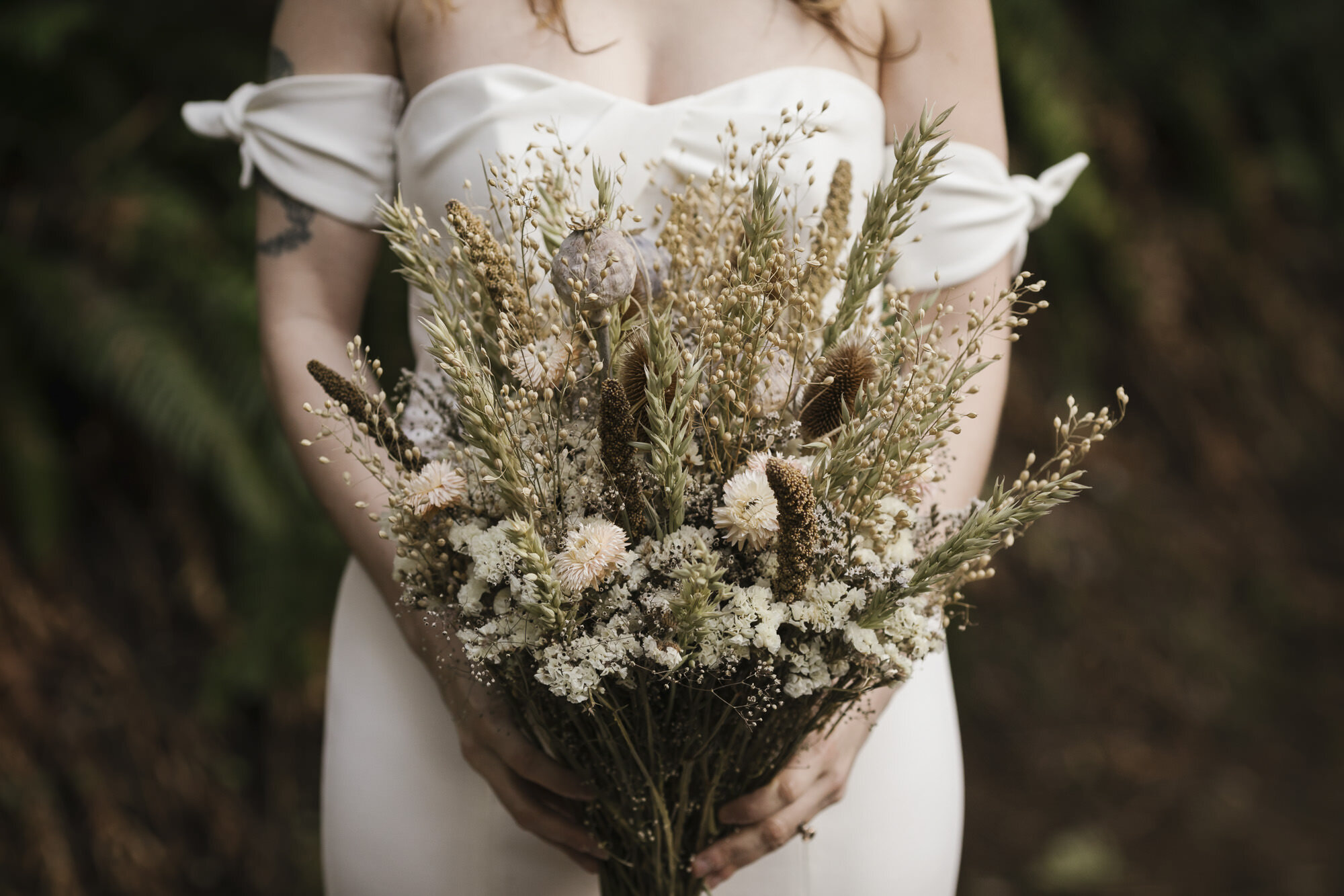 PNW bride holds bouquet of dried flowers on her wedding day in Washington