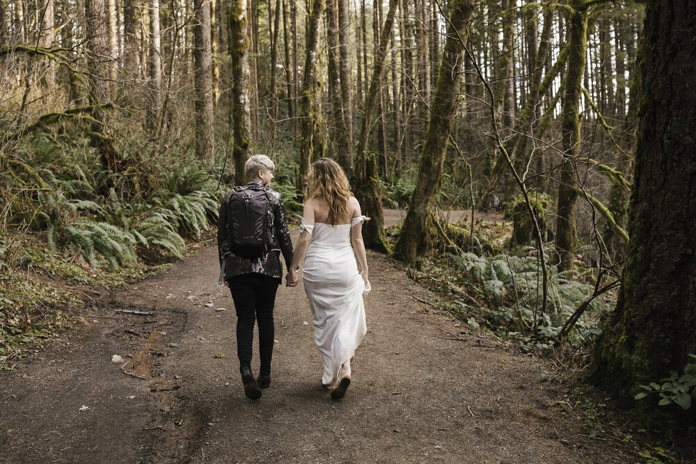 Same sex couple hike through the Washington forest for their elopement