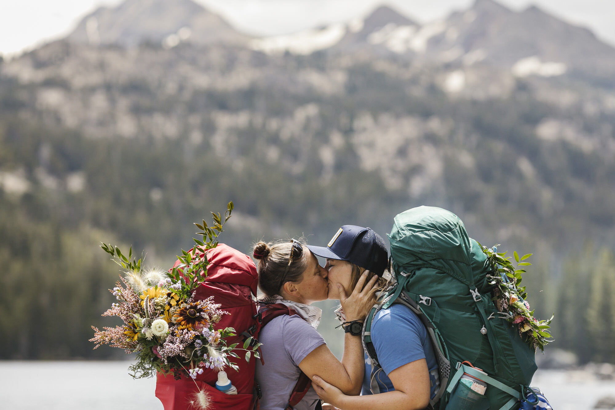 About to be married couple kiss in front of the Sierra Nevada Mountains during their hiking elopement