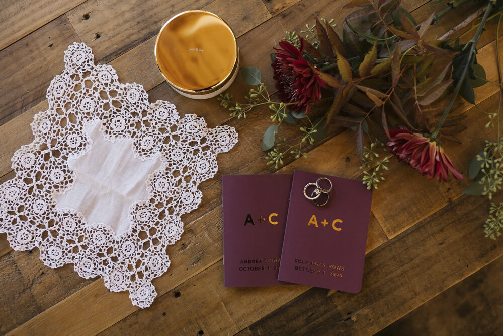 Shot of personal wedding details: rings, vow books, grandmother's handkerchief, during adventurous elopement in Tahoe