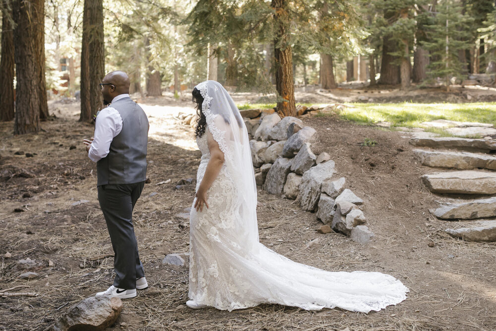 Bride approaches her groom for their first look in the Tahoe forest on their wedding day