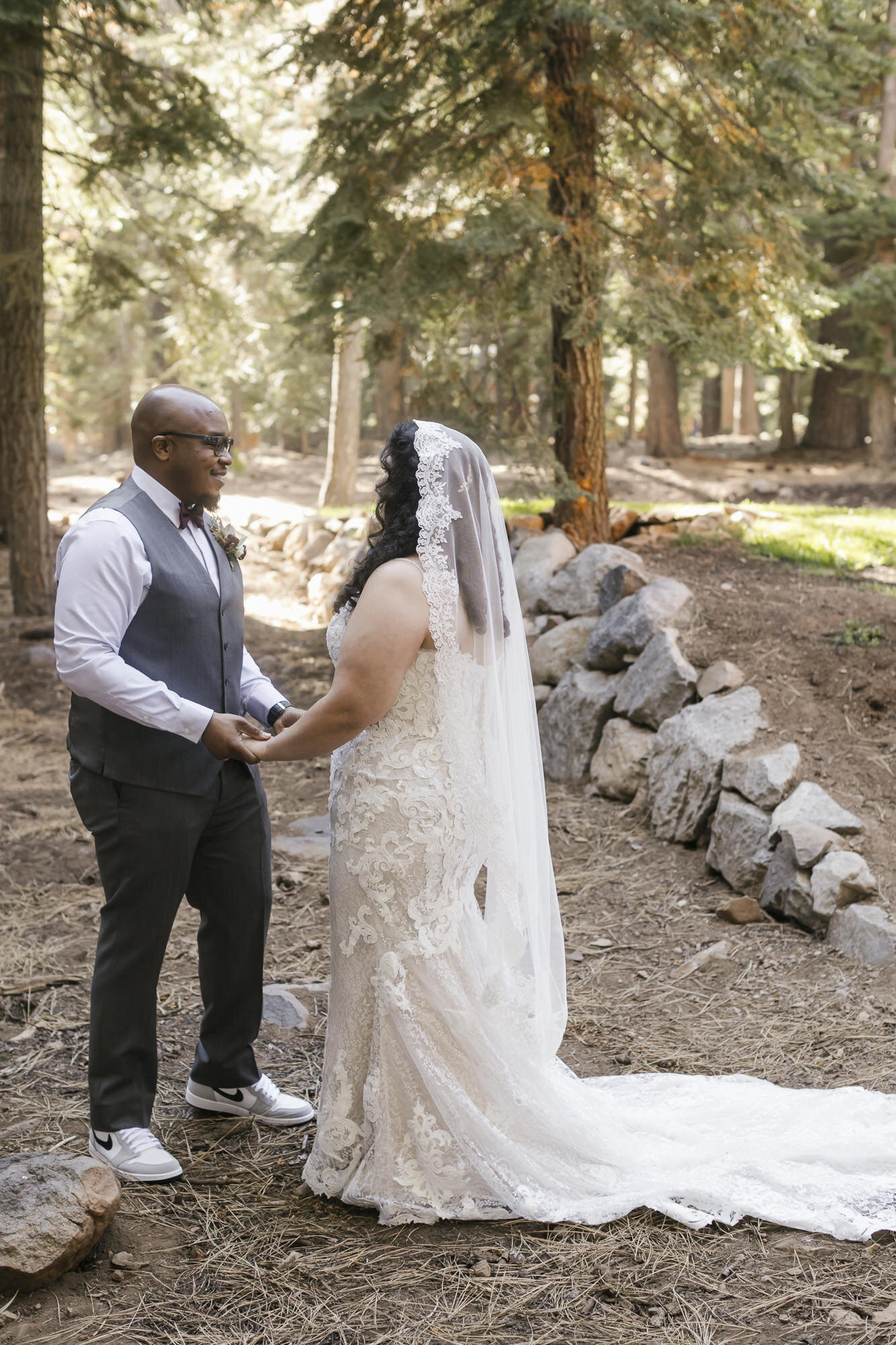 Bride and groom hold hands during their first look in Tahoe on their wedding day
