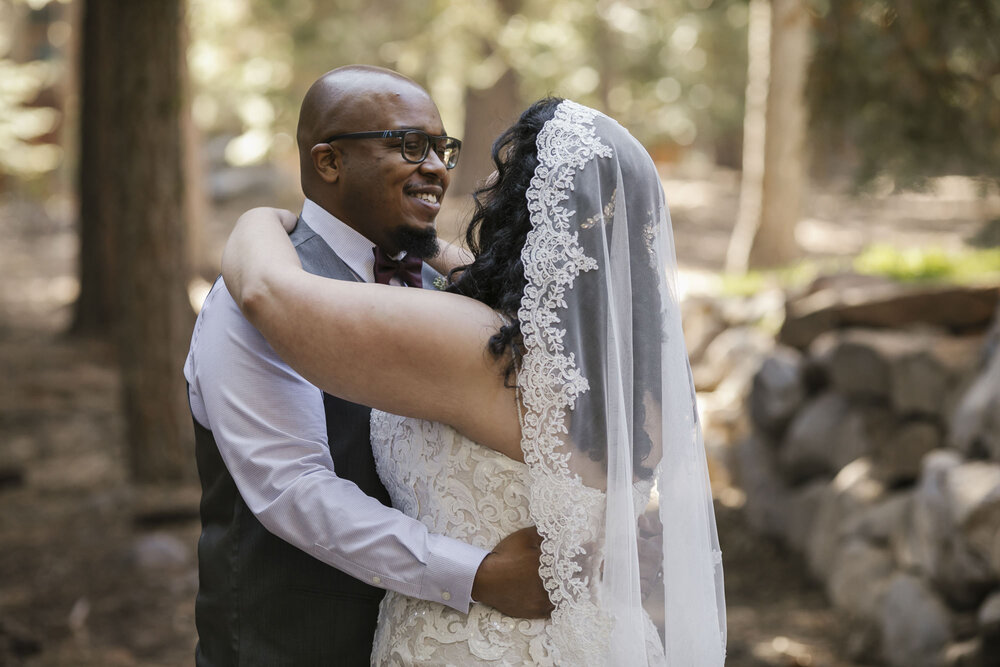 Groom smiles happily at this bride during their wedding day first look