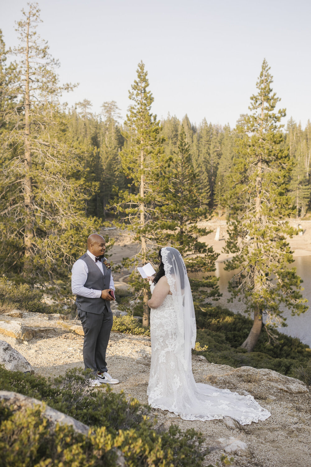 Wedding couple read from their vow books during their elopement in the forest