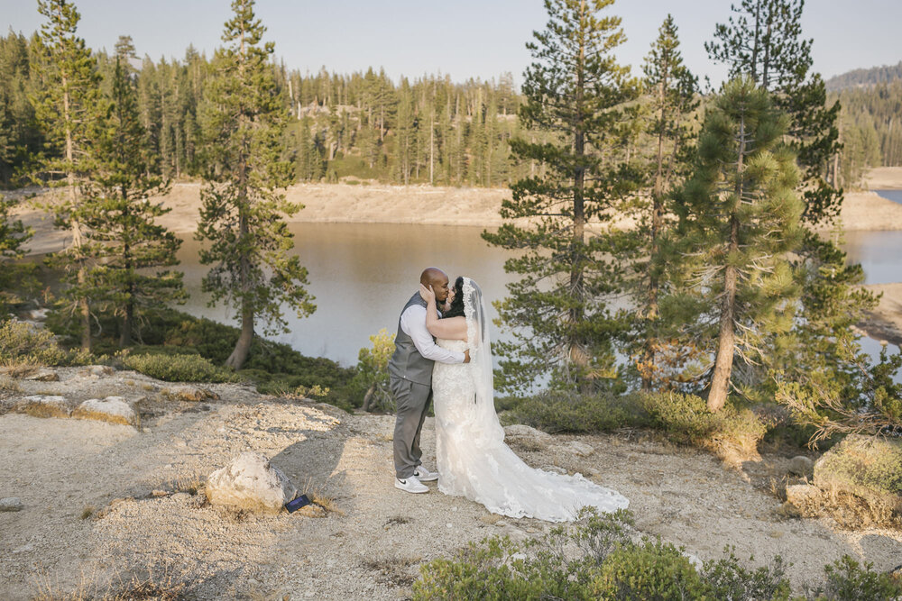 Wedding couple share their first kiss after exchanging vows in the Tahoe forest