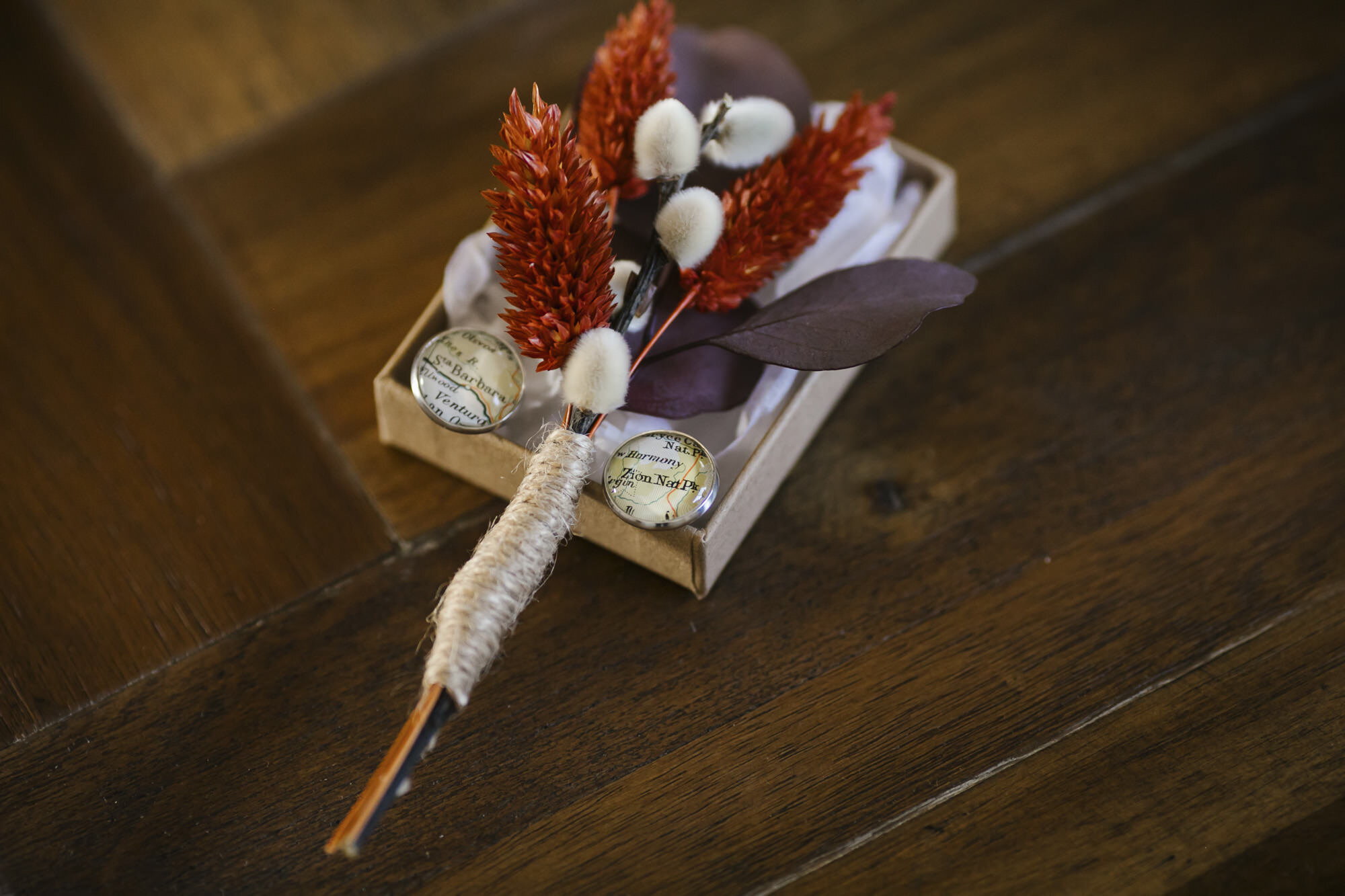 Artificial flower boutonniere and custom map wedding cufflinks