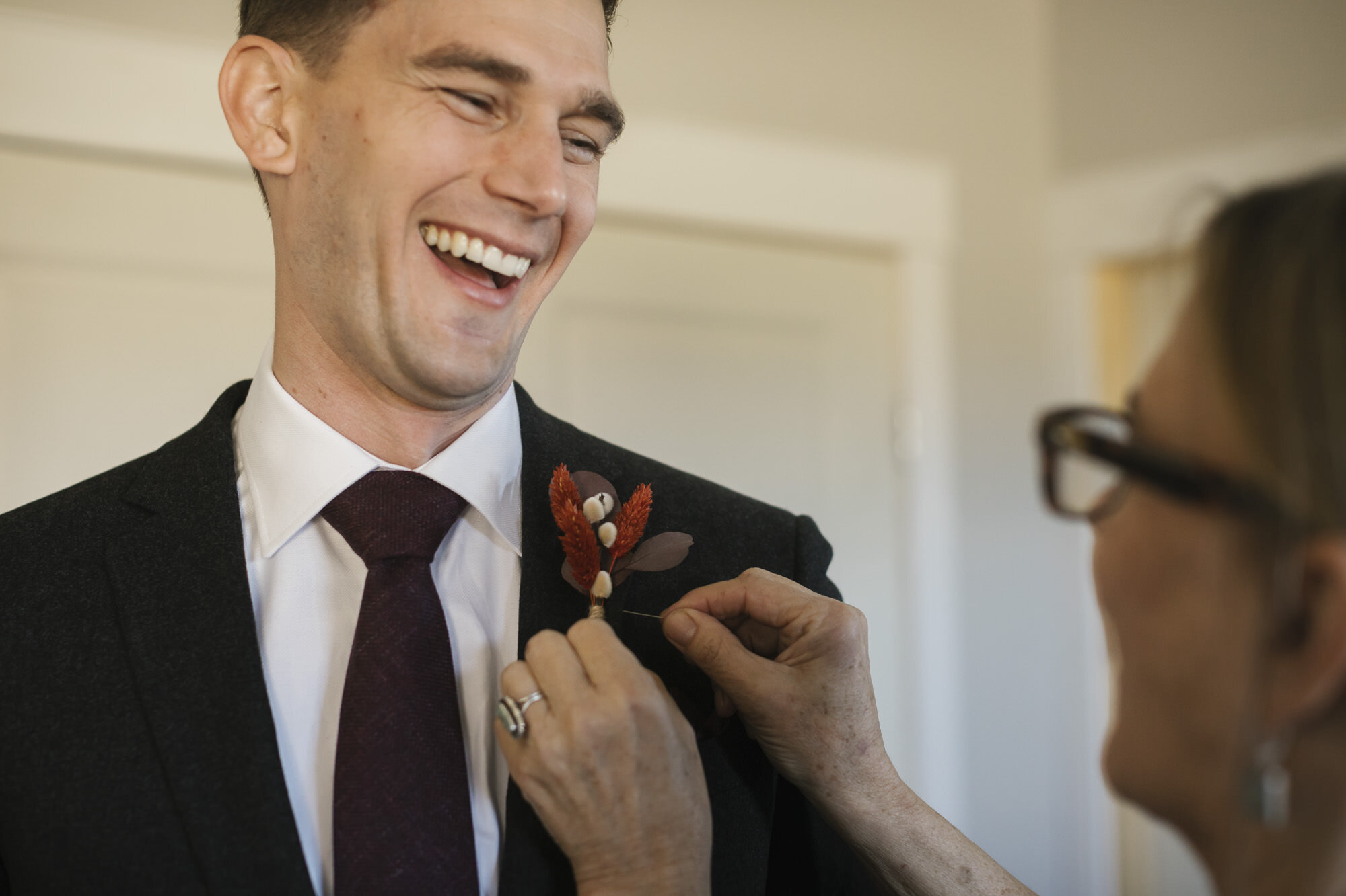 Utah groom laughs as his mother pins his wedding boutonniere