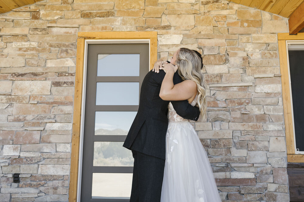 Wedding couple hug after their first look outside their Utah Airbnb