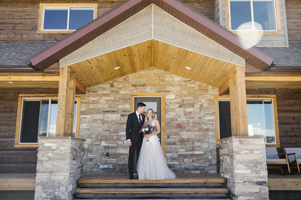 Wedding couple stand on the porch of their Airbnb in the Utah desert