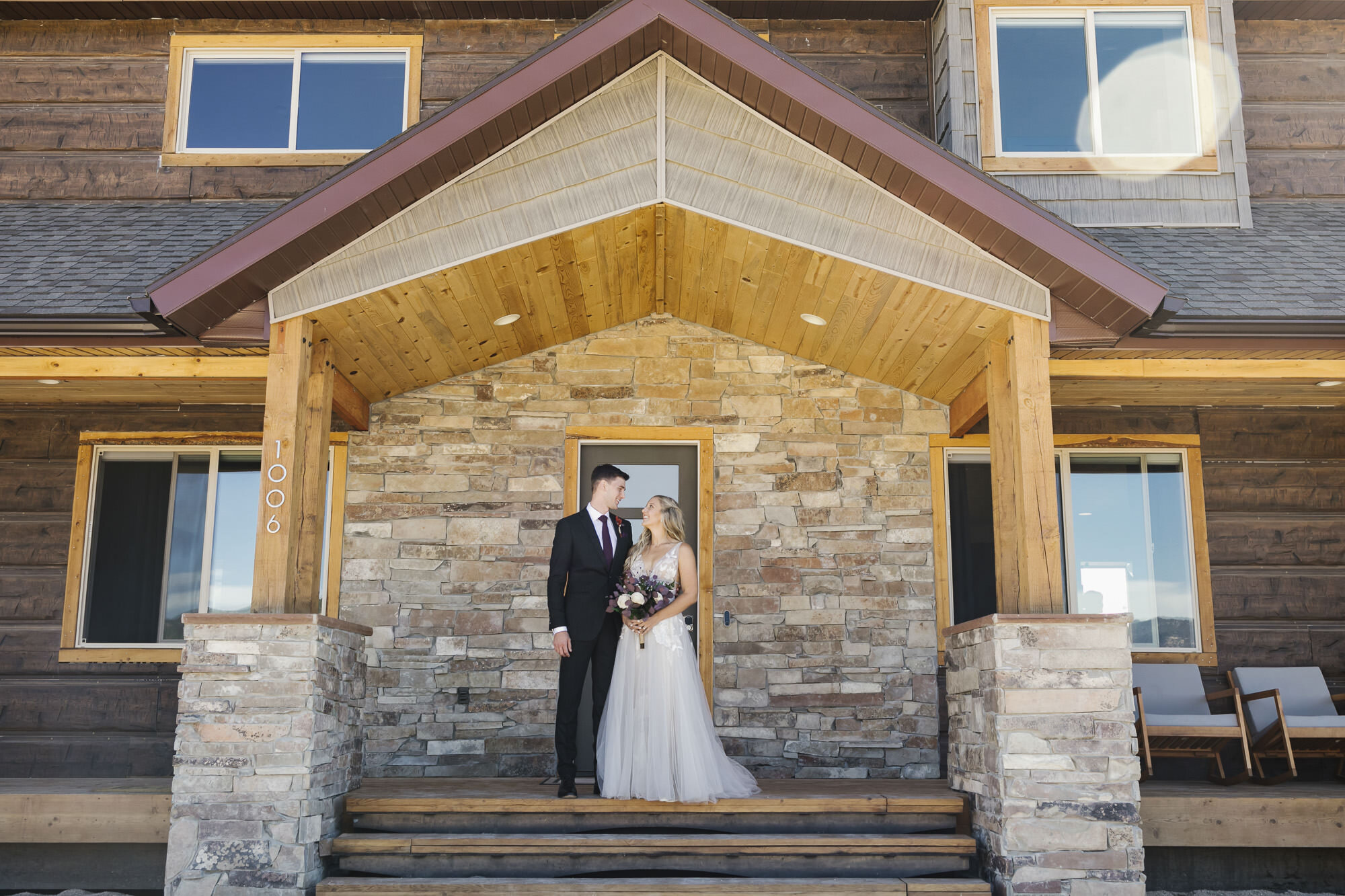 Wedding couple stand on the porch of their Airbnb in the Utah desert