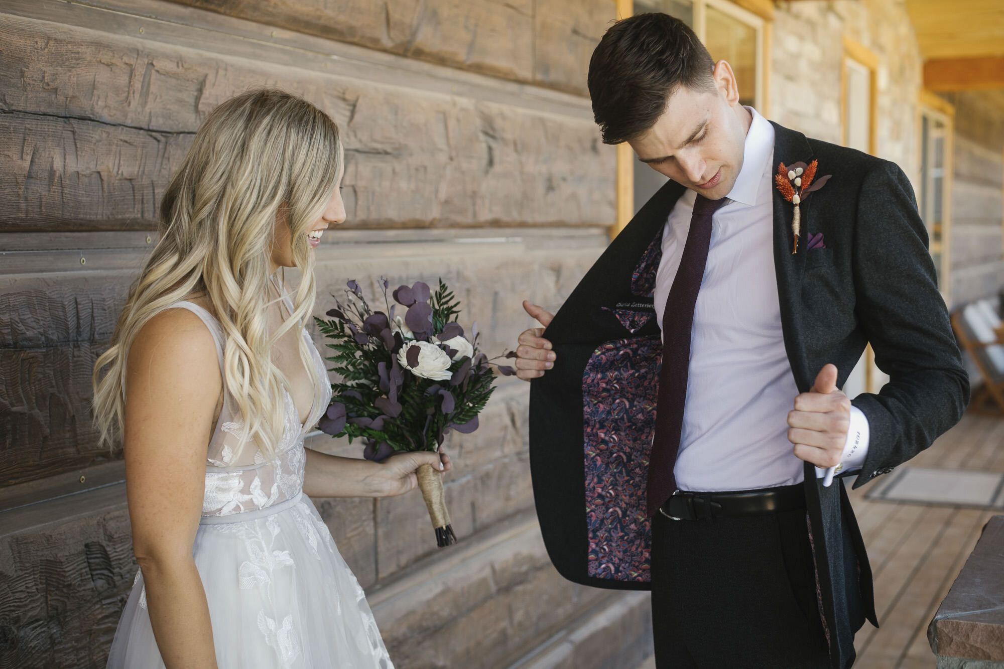 Groom shows off the custom liner of his wedding suit jacket