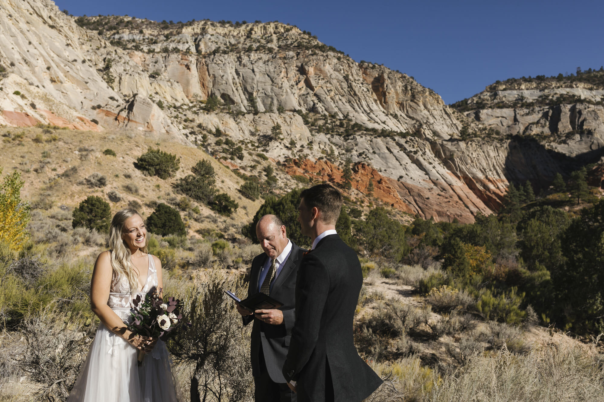 Bride and groom stand together at a gorgeous canyon location during their Utah desert wedding